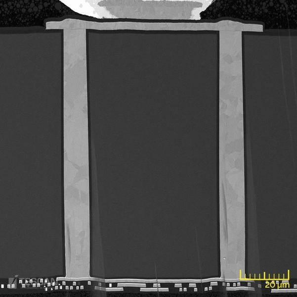BSE cross-sectional view of 2.5D stacked-die showing two Cu TSVs passing through silicon interposer in order to connect upper metal layers to additional backside metal layers